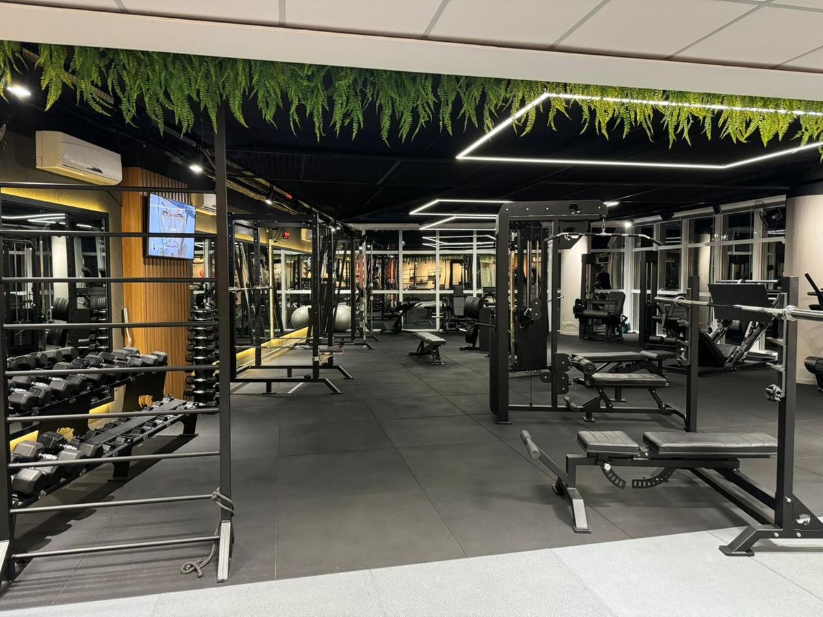 Área de musculação com equipamentos e halteres